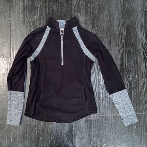 Black and grey quarter zip with thumb holes. Pops of peach on the inside.